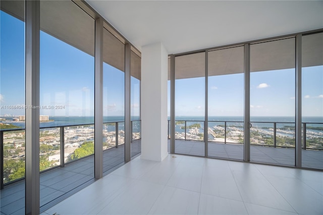 unfurnished sunroom featuring a beach view and a water view