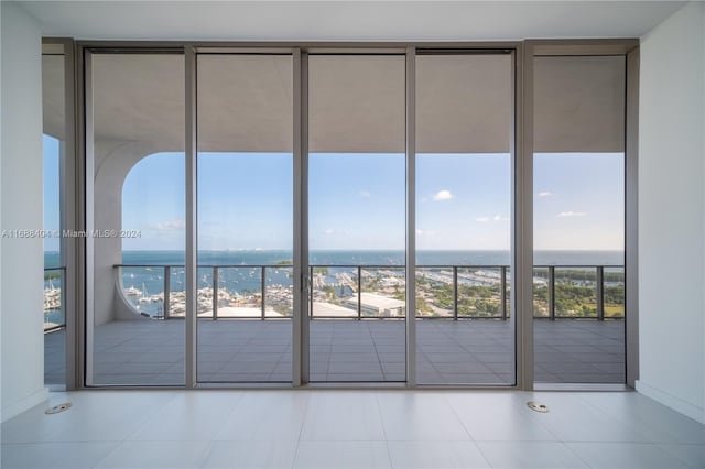 entryway with light tile patterned floors and a water view