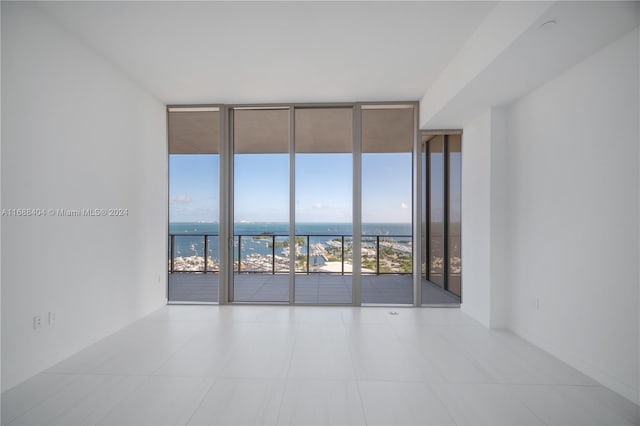 unfurnished room featuring a water view and floor to ceiling windows