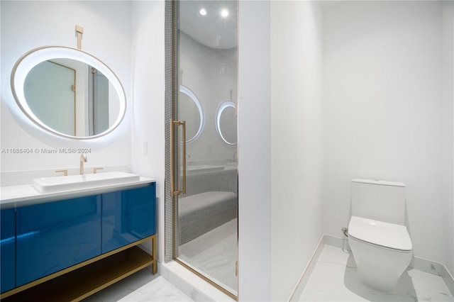 bathroom featuring vanity, toilet, and a shower with shower door