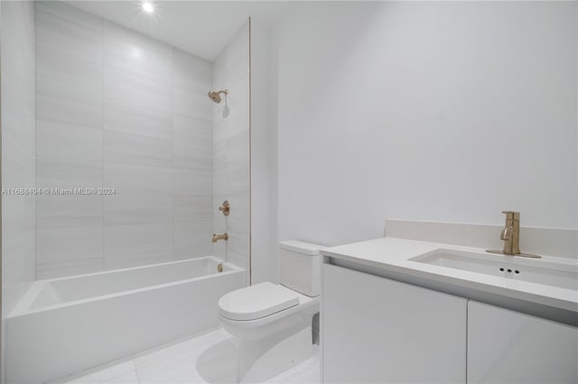 full bathroom featuring toilet, tiled shower / bath combo, vanity, and tile patterned flooring