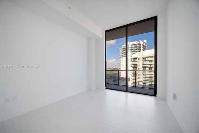 tiled empty room featuring floor to ceiling windows