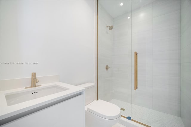 bathroom featuring vanity, toilet, and a shower with shower door