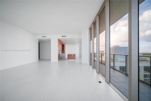 spare room with a wall of windows and plenty of natural light