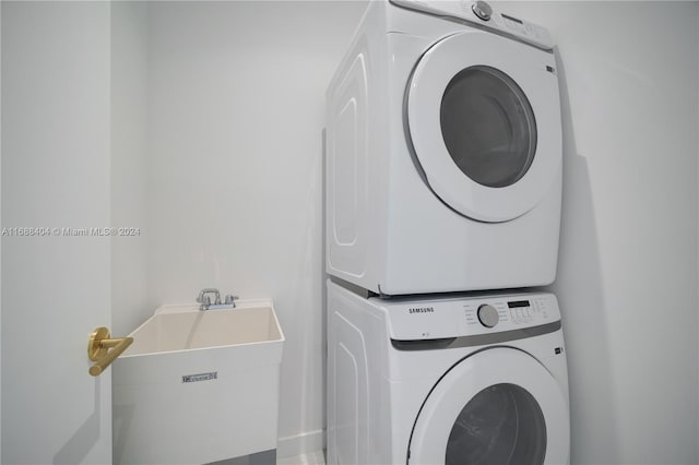 laundry area featuring stacked washing maching and dryer and sink