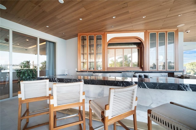 bar with a wealth of natural light, wood ceiling, and vaulted ceiling