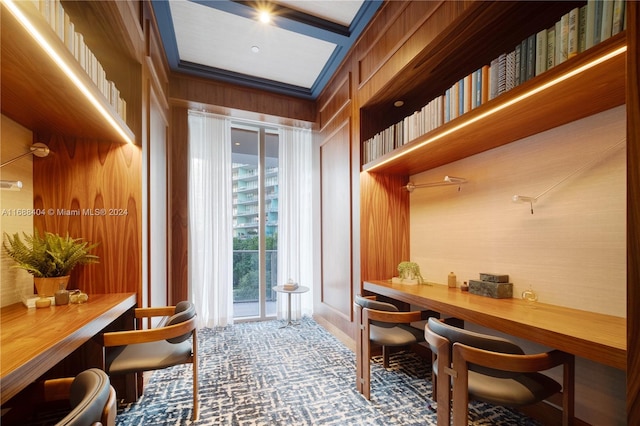 office featuring wood walls, built in desk, and crown molding