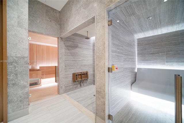 bathroom with a shower and tile walls