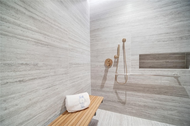 bathroom featuring tile walls and a shower