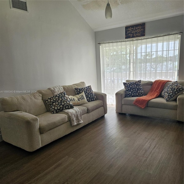 living room with vaulted ceiling, a textured ceiling, and dark hardwood / wood-style flooring