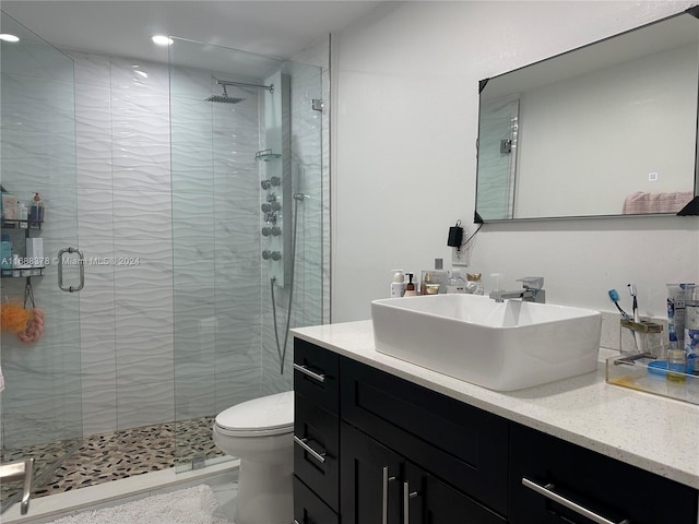 bathroom with toilet, an enclosed shower, and vanity