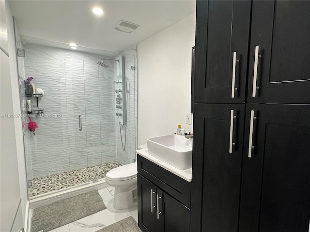 bathroom with a shower with shower door, vanity, and toilet