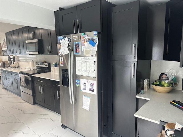 kitchen featuring tasteful backsplash, light stone countertops, and appliances with stainless steel finishes