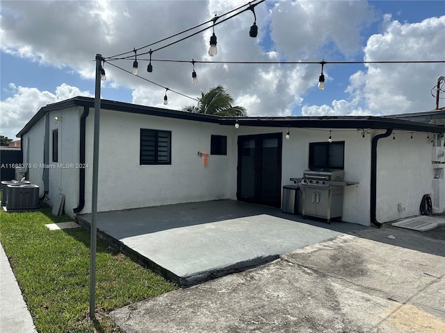 rear view of house with central air condition unit and a patio area