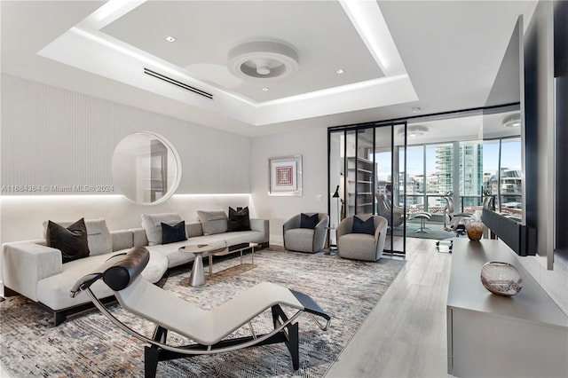 living room with a tray ceiling and hardwood / wood-style floors