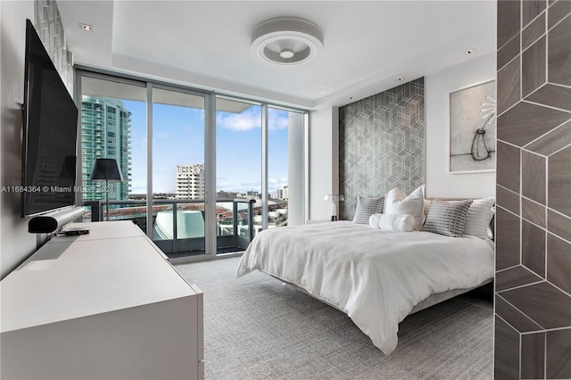 carpeted bedroom featuring access to exterior and a wall of windows