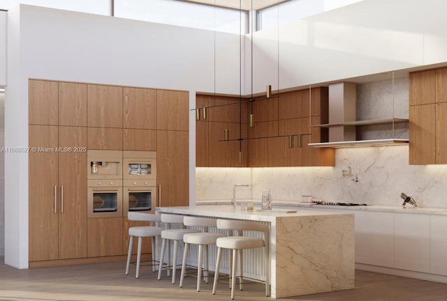 kitchen featuring tasteful backsplash, a high ceiling, stainless steel oven, and a kitchen bar