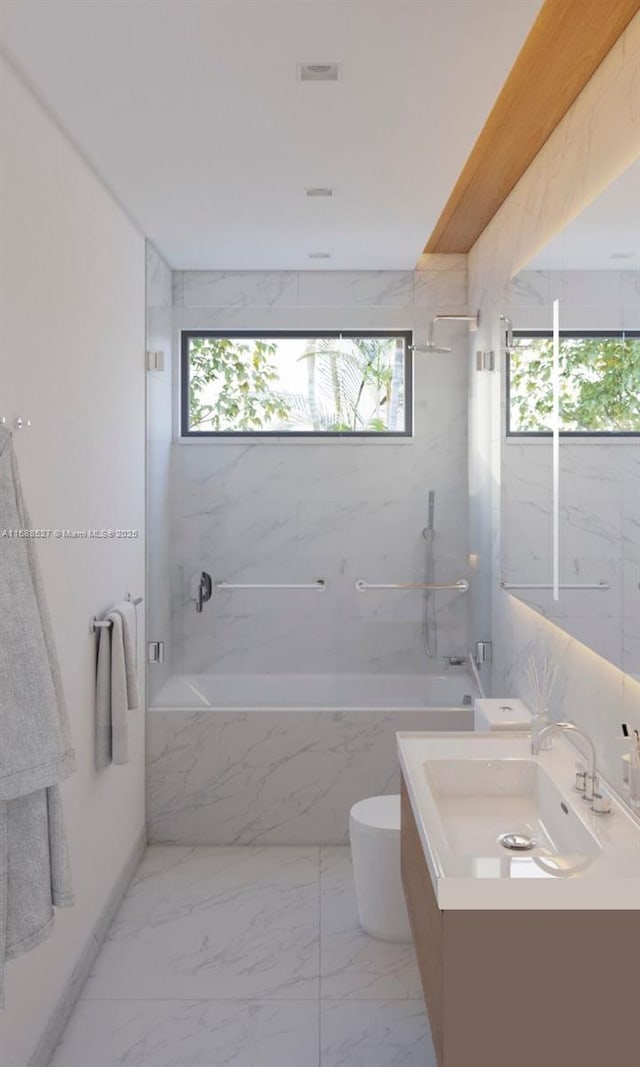 bathroom featuring vanity, tiled shower / bath, and a healthy amount of sunlight