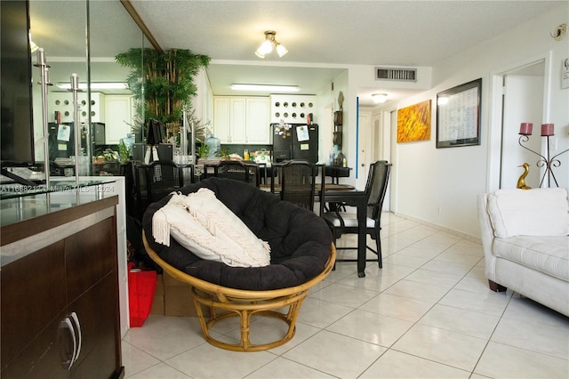 living room with a textured ceiling, light tile patterned floors, and ornamental molding