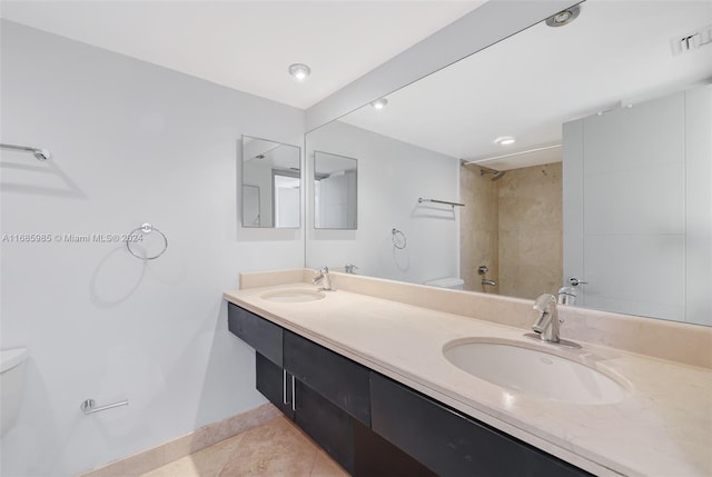 full bathroom featuring tile patterned flooring, vanity, tiled shower / bath combo, and toilet