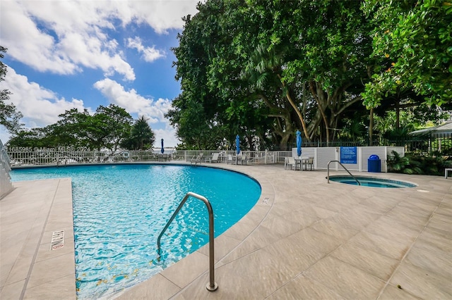 view of swimming pool featuring a patio and a hot tub