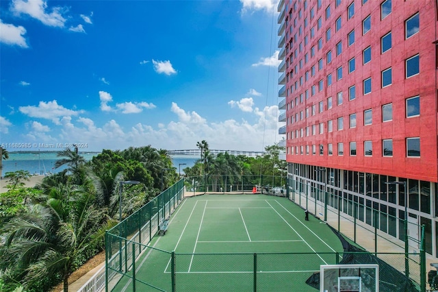 view of tennis court featuring a water view