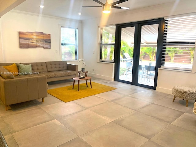 tiled living room featuring ceiling fan, plenty of natural light, french doors, and ornamental molding