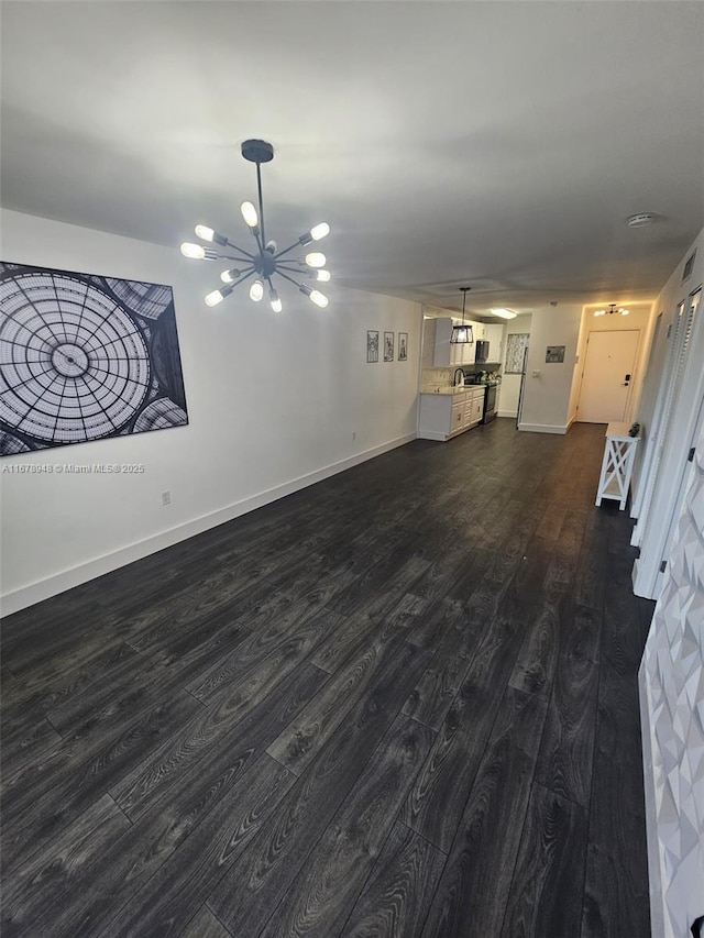 unfurnished living room with dark hardwood / wood-style flooring and an inviting chandelier