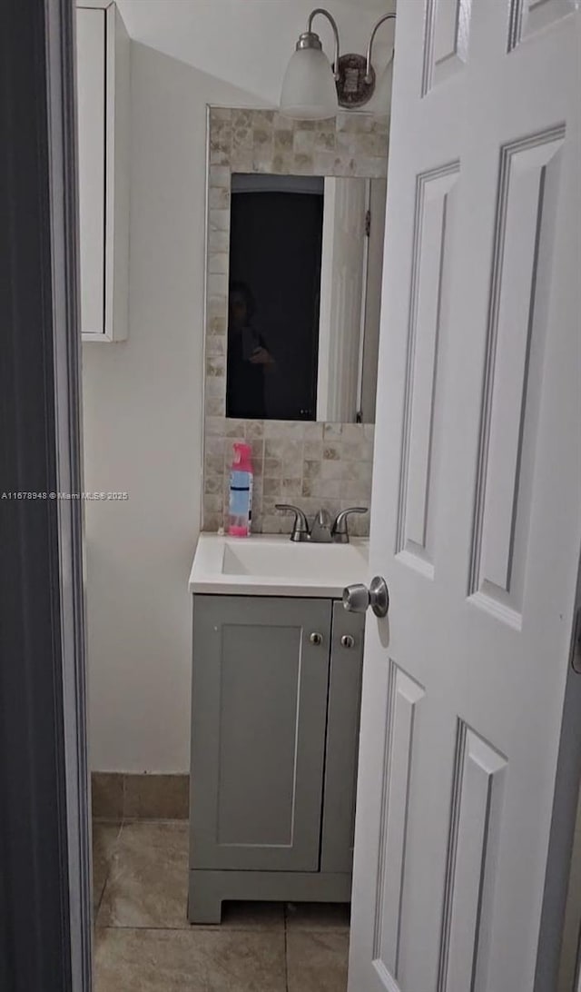 bathroom with tile patterned flooring, vanity, and backsplash