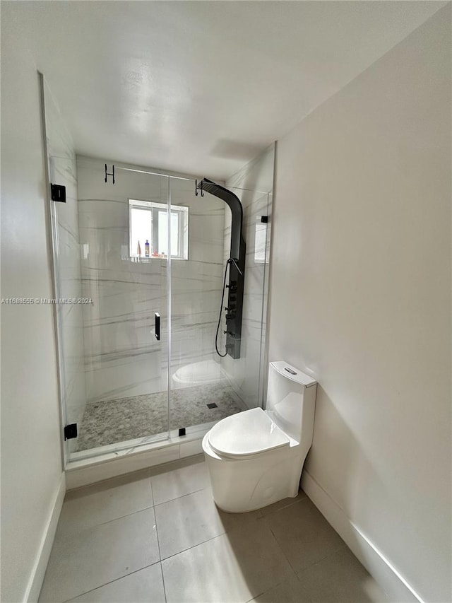 bathroom with tile patterned flooring, toilet, and a shower with door