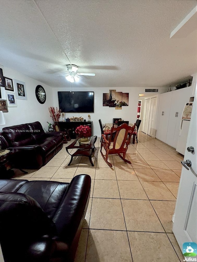 tiled living room with a textured ceiling and ceiling fan