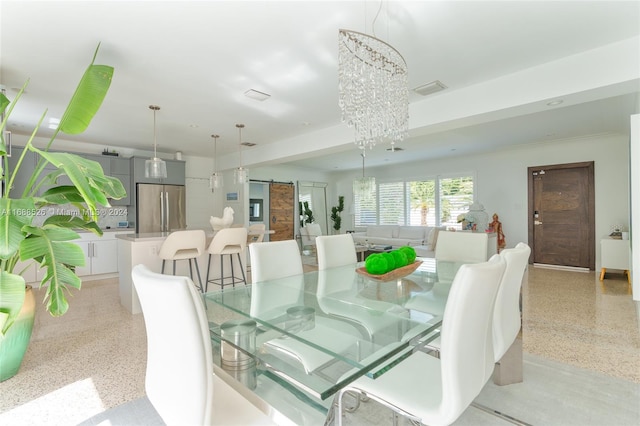 dining area featuring a chandelier and a barn door