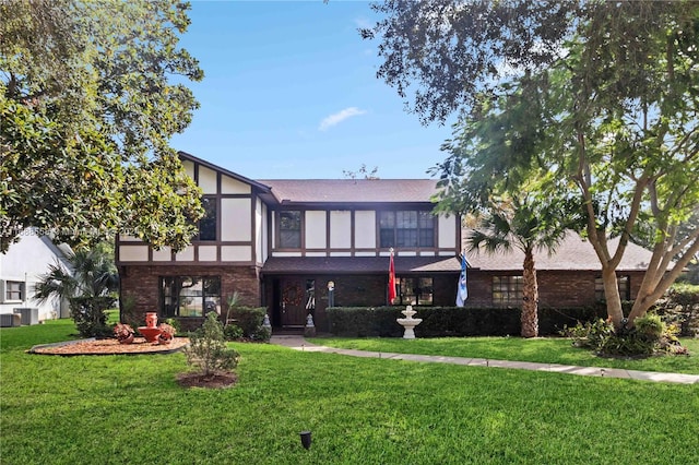 view of front of house with central AC unit and a front lawn