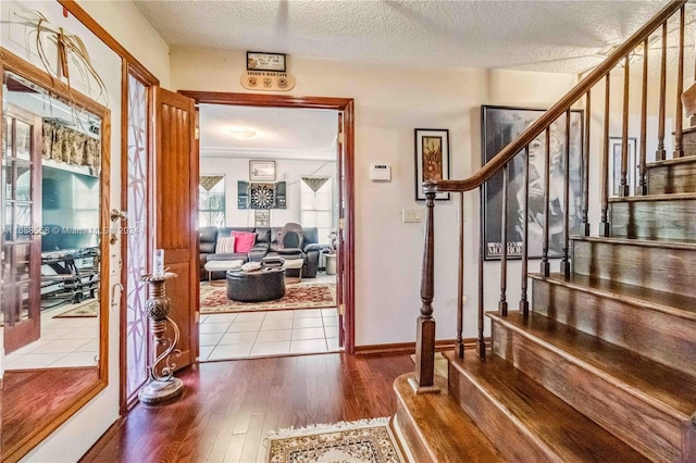 foyer entrance featuring hardwood / wood-style floors and a textured ceiling