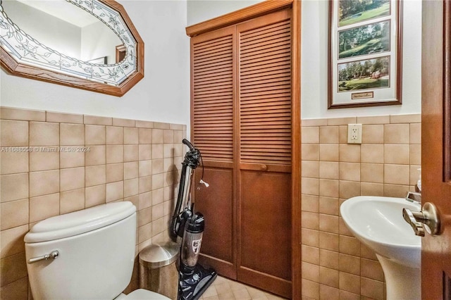 bathroom with tile walls and toilet