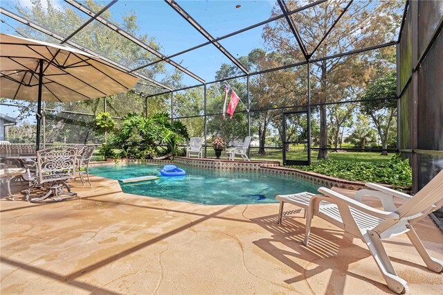 view of swimming pool featuring a lanai and a patio