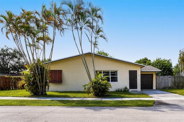 view of front of property featuring a garage and a front lawn