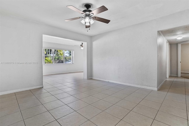 empty room with light tile patterned floors and ceiling fan