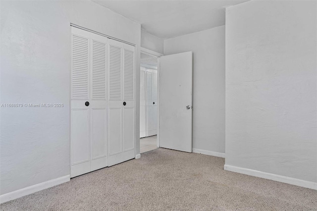 unfurnished bedroom with light colored carpet and a closet