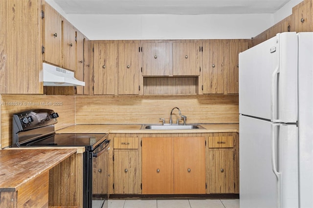 kitchen featuring sink, tasteful backsplash, light tile patterned floors, black / electric stove, and white fridge