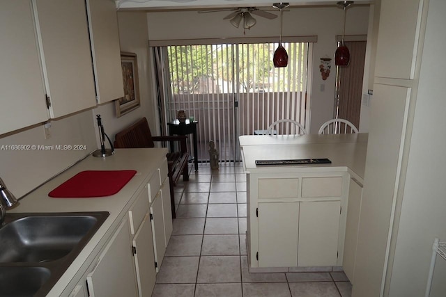 kitchen featuring white cabinetry, sink, ceiling fan, light tile patterned floors, and pendant lighting