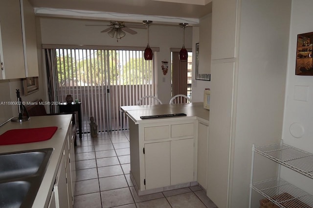 kitchen featuring white cabinetry, light tile patterned floors, pendant lighting, and kitchen peninsula