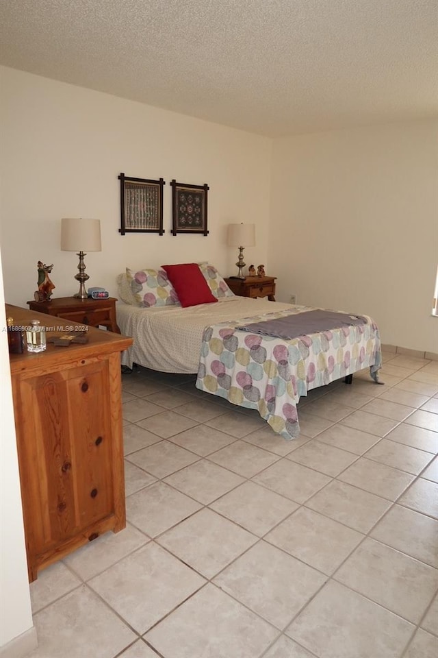 bedroom with a textured ceiling and light tile patterned floors