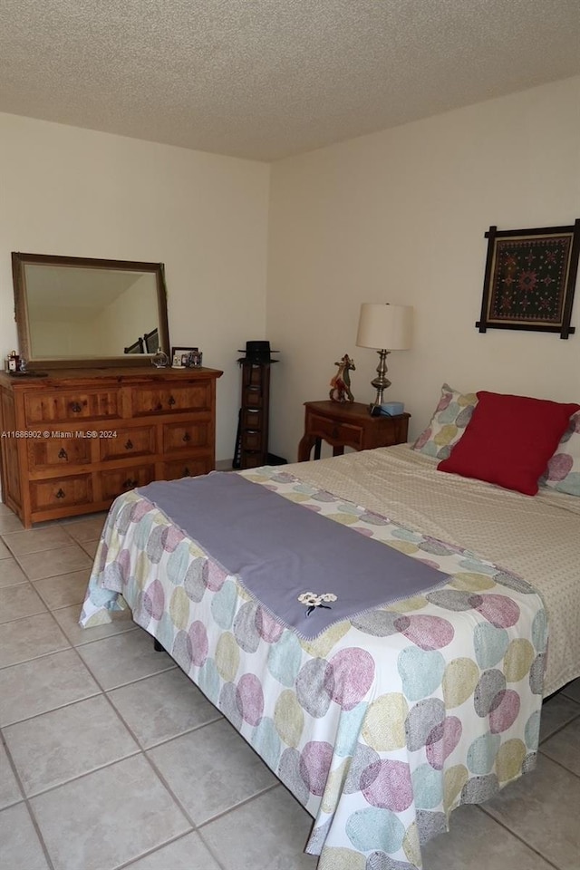 bedroom featuring a textured ceiling and light tile patterned floors