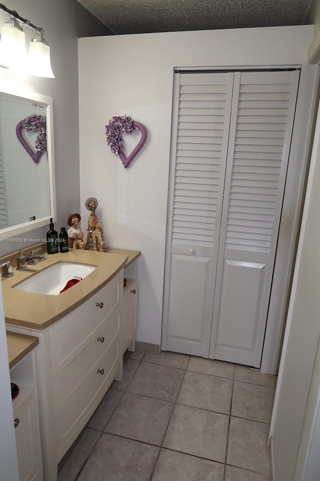 bathroom featuring vanity, a textured ceiling, and tile patterned floors