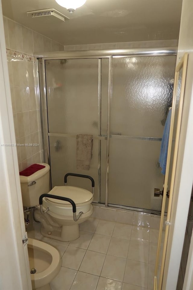 bathroom with tile patterned flooring, an enclosed shower, a bidet, and toilet