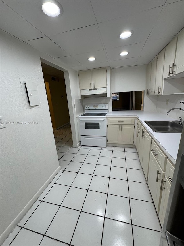 kitchen with light tile patterned flooring, sink, and white range with electric cooktop