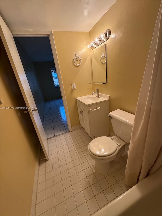 bathroom with toilet, vanity, and tile patterned floors