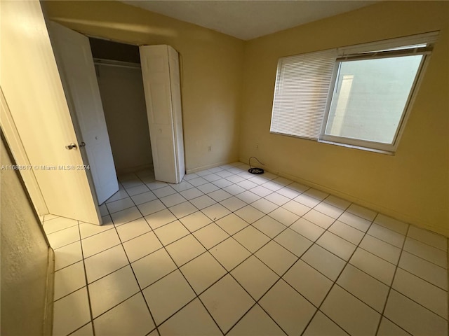 unfurnished bedroom with light tile patterned flooring and a closet