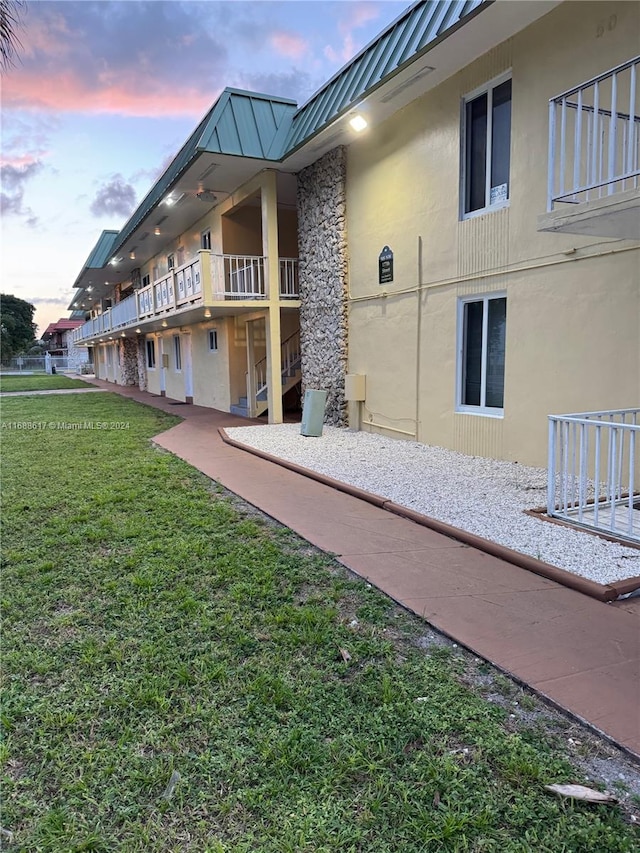 exterior space featuring a lawn and a balcony